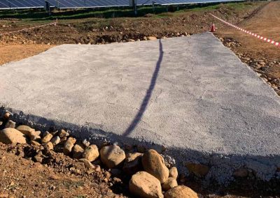 Losa de hormigón terminada junto a filas de paneles solares